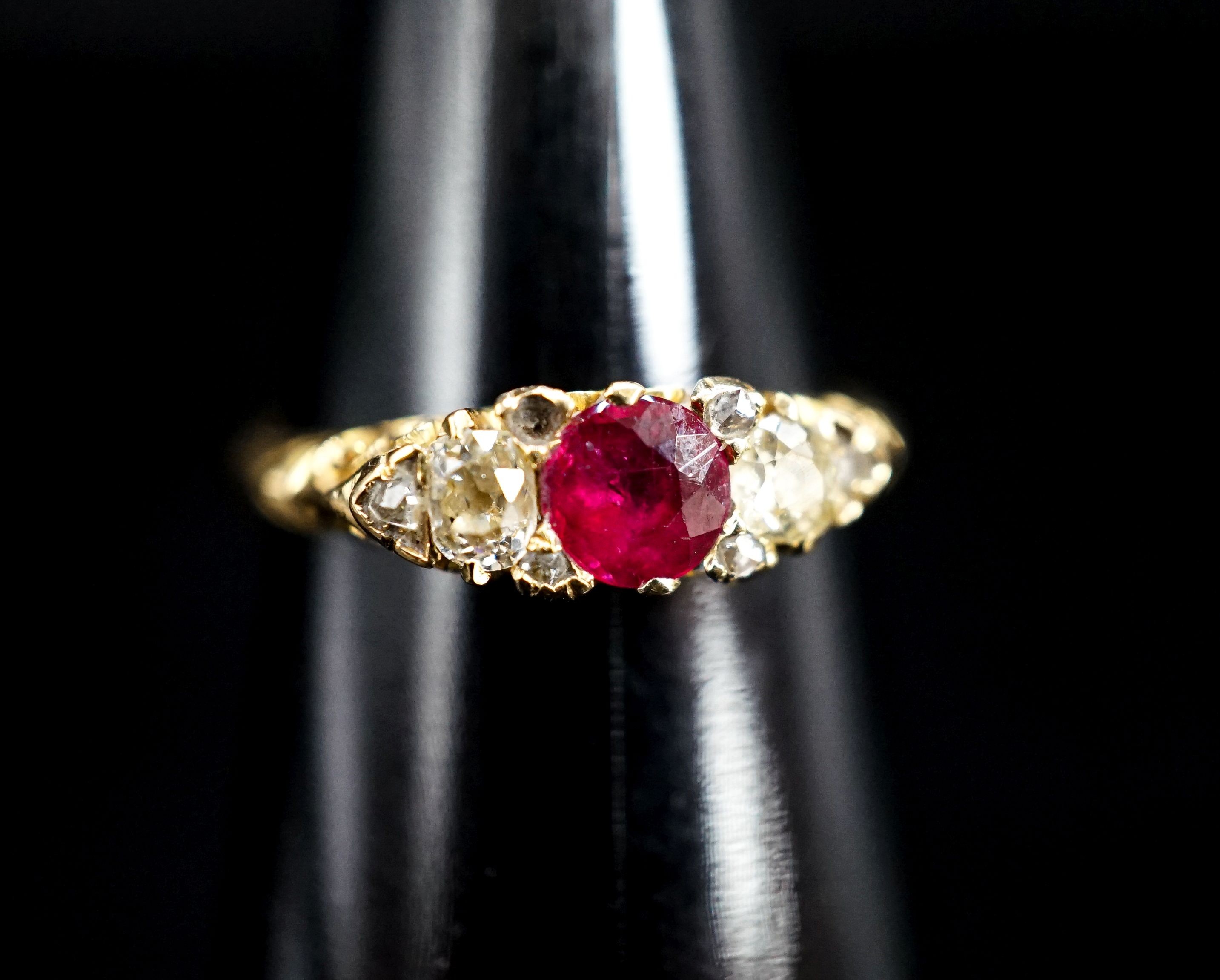 An Edwardian 18ct gold, ruby and diamond three stone ring, with diamond chip spacers (one missing), size N, gross weight 3.3 grams.